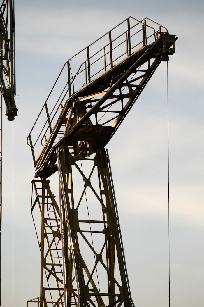 Silhouette of an industrial crane against a clear sky, showcasing modern construction equipment.